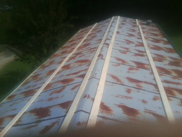 Rusted metal roof panels with new wood purlins before replacement — Storm Damage Roof Repair in Newborn by Roofing Brothers
