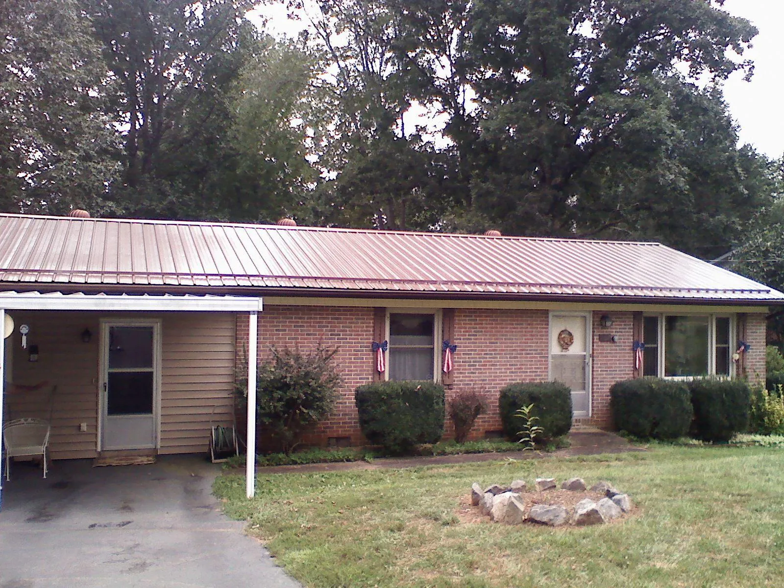 Bronze metal roof and carport on a brick ranch home — Roof Repair work by our crew in Newborn