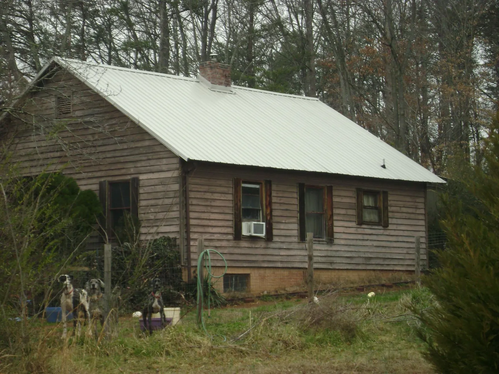 White metal roof on an old wood sided farmhouse, from a Metal Roof Installation job in Newborn